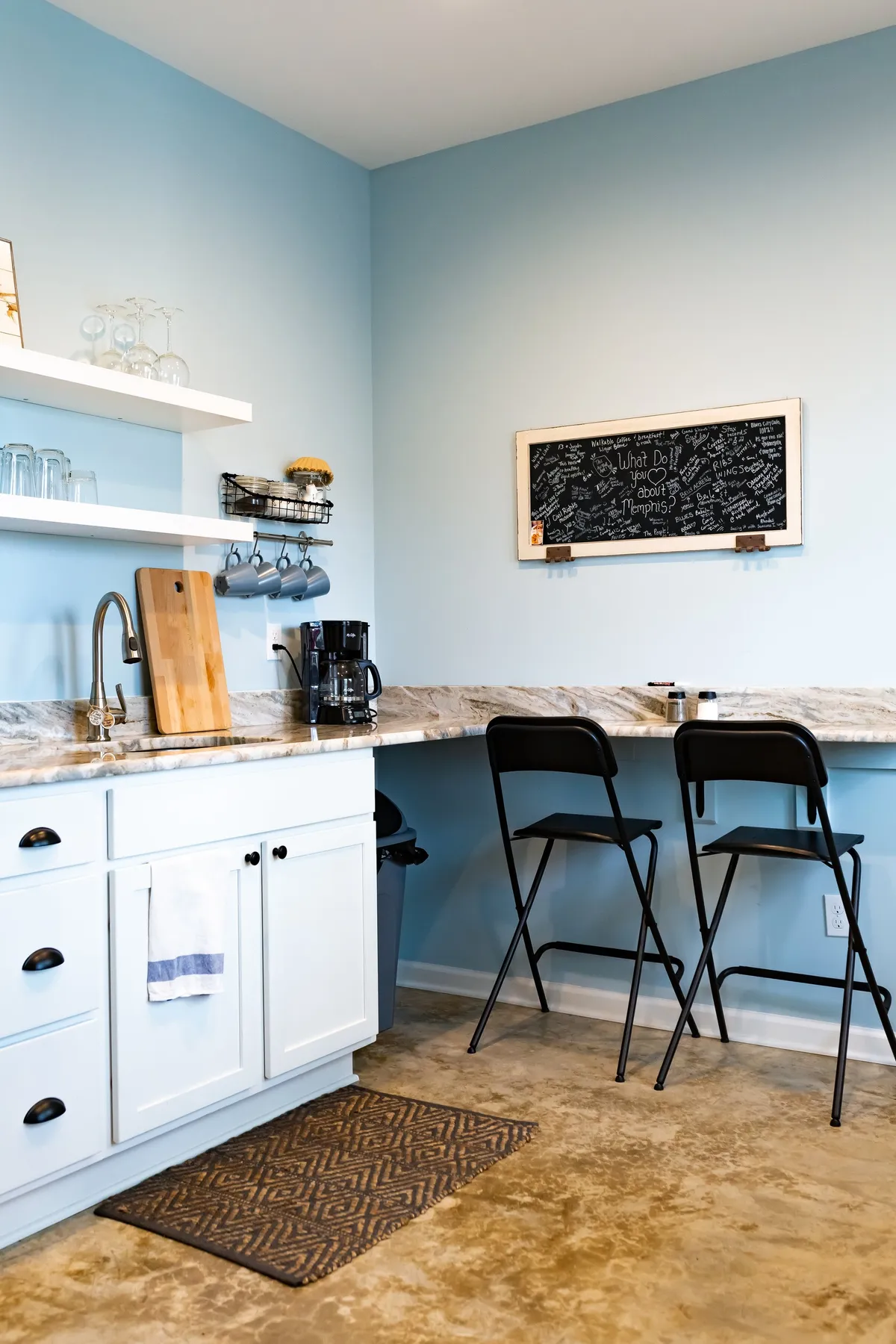 A granite kitchen countertop with inviting bar stools and a chalkboard covered in friendly messages, creating an atmosphere of relaxed socializing and easy mornings over coffee.